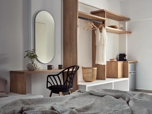 拉加纳斯Cassiopeia Rooms & Suites的一间卧室配有一张床、镜子和椅子