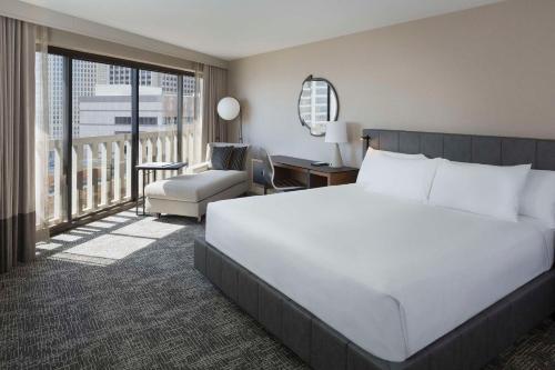 旧金山Hyatt Regency San Francisco的卧室配有一张白色大床和一把椅子