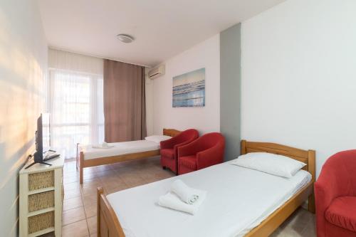 诺维格勒达尔马提亚Hotel Rooms Roccia的一间卧室配有一张床和两张红色椅子
