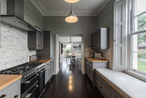 KingskerswellThe Surveyors House Devon, Luxury Victorian Villa in Torbay的厨房配有白色橱柜和炉灶烤箱。