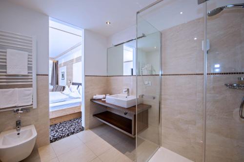 塞尔瓦迪加尔代纳山谷Hotel Garni Aghel的一间带水槽和玻璃淋浴的浴室