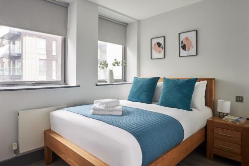 伦敦Wembley Stadium by Viridian Apartments的一间卧室配有一张带蓝色枕头的大床