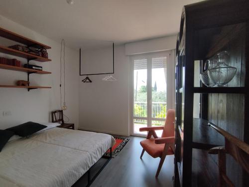 托尔博莱Casa di Nin的卧室配有床、椅子和窗户。