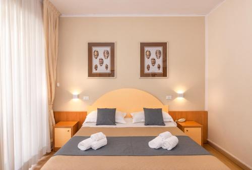 维亚雷焦斯特拉德意大利酒店的一间卧室配有一张床,上面有两条毛巾