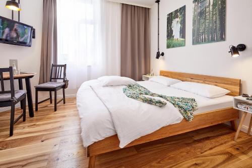 科隆克罗蒂维格普拉斯酒店的卧室配有1张床、1张桌子和1把椅子