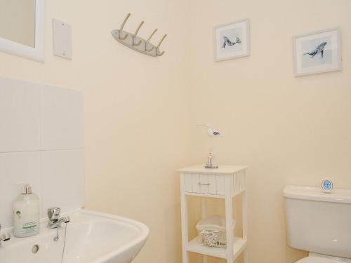 法尔茅斯Woodmans Cottage的浴室配有白色卫生间和盥洗盆。