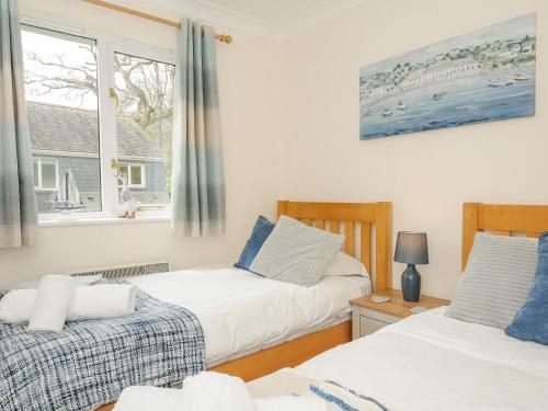 法尔茅斯Woodmans Cottage的一间卧室设有两张床和窗户。