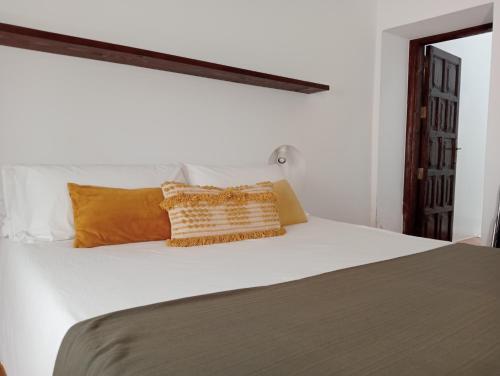 阿雷西费Casa Mocan的卧室配有带橙色枕头的白色床