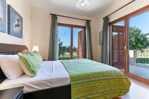 库克里亚3 bedroom Villa Athina with private pool and golf views, Aphrodite Hills Resort的一间卧室设有一张床和一个阳台