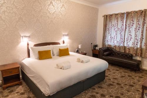 梅德斯通Hamlet Hotels Maidstone的酒店客房带一张大床和一把椅子