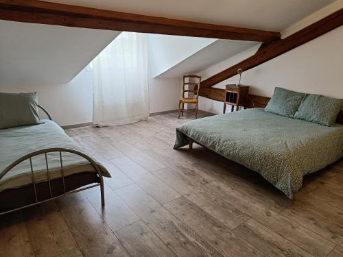 CamuracGîte dans les Pyrénées的阁楼卧室配有床和椅子