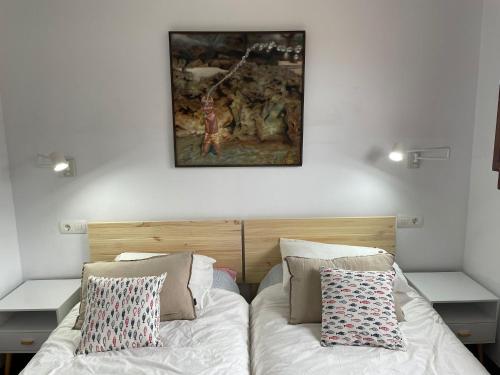 里瓦德塞利亚Casa Mojapies的一间卧室设有两张床,墙上挂着一幅画