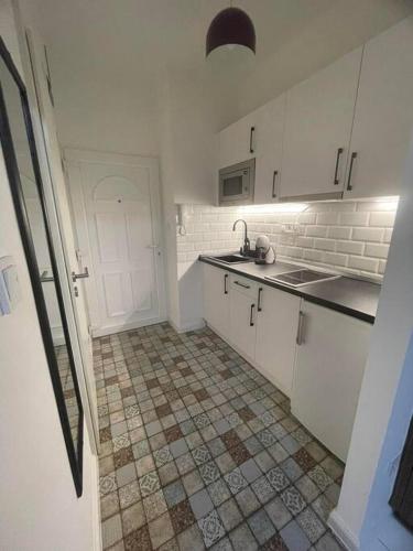 佐洛埃格塞格Geri Mini Home的厨房配有白色橱柜和瓷砖地板。