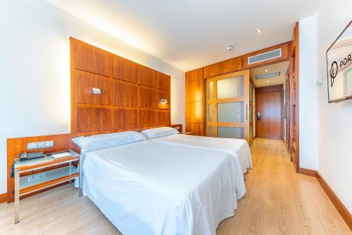 马尼塞斯Port Azafata Valencia的卧室配有一张白色大床和木制橱柜。