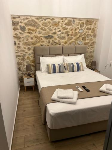 雅典Technopolis Luxury Apartments的一间卧室设有两张床和石墙