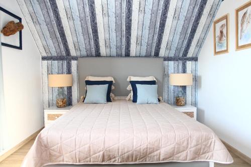 斯蒂格纳Biały Domek的一间卧室配有一张带蓝白色窗帘的床