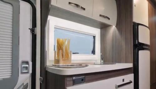 法鲁Portugals Infinity - AutoCaravana Luxo的厨房配有水槽和镜子,位于走廊