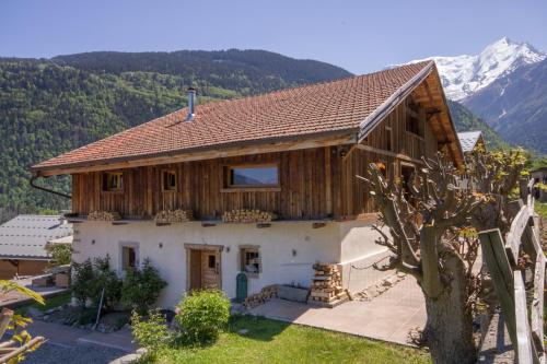 圣热尔韦莱班Wanderful Life MontBlanc refuge haut de gamme的一座大木房子,背景是群山