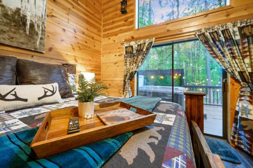 布罗肯鲍Hickory Bear - Cabin surrounded by pines, Sleeps 10, Hot Tub, Fire Pit, Arcade, Foosball Table & Deck Slide的一间卧室配有一张床,上面有托盘