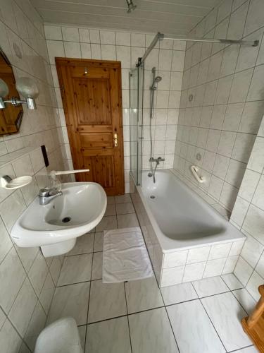 MünkFerienwohnung zum Nürburgring的浴室配有盥洗盆、浴缸、卫生间和盥洗盆。