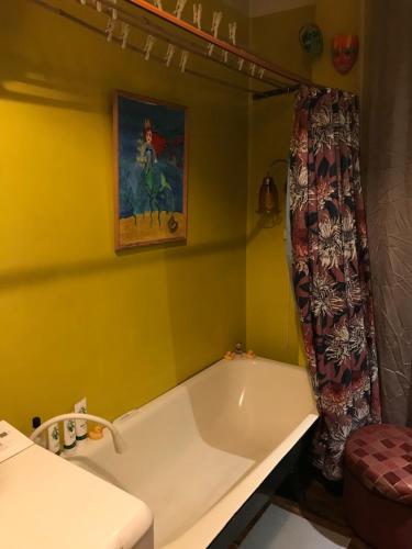 里加Cozy condo for up to 3 travellers, with kitchen and bath的浴室设有黄色墙壁上的白色浴缸