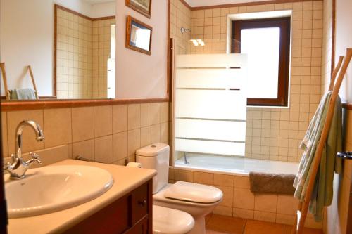 瓦伦西亚德奥尼Apartament rústic amb llar de foc by RURAL D'ÀNEU的浴室配有盥洗盆、卫生间和浴缸。
