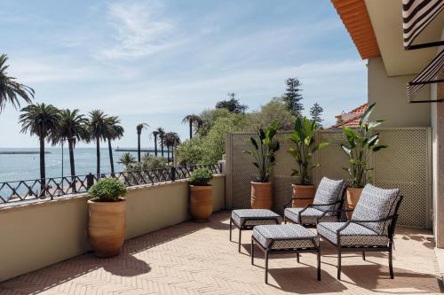 波尔图Portie Deluxe Suites by DA'HOME的阳台配有椅子,享有海景。
