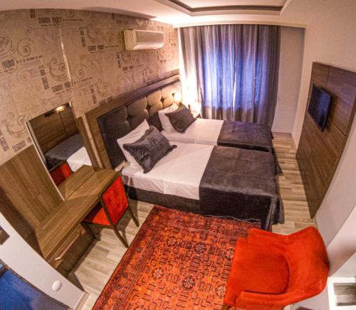 阿克恰阿巴德New Akçaabat Hotel的酒店客房,配有床、桌子和椅子