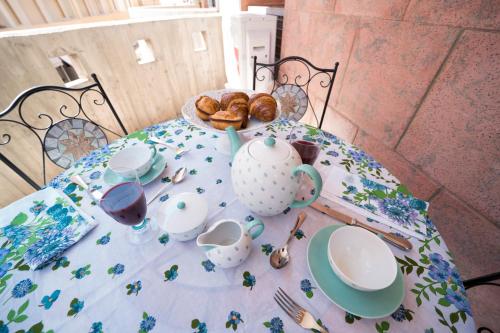 加利波利Sunset home Baia Blu的餐桌,带茶壶和糕点的桌布