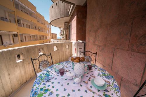 加利波利Sunset home Baia Blu的阳台上的餐桌上放着一盘食物
