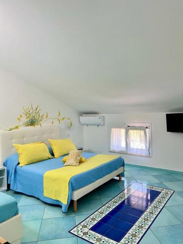 卡斯特拉巴特B&B A Casa di Vittoria - Guest House的一间卧室配有一张黄色和蓝色床单的床
