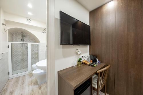 卡塔尼亚B&B Ambitious的一间带卫生间的浴室和墙上的电视