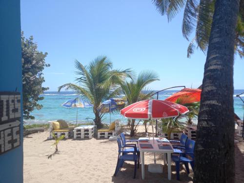 圣弗朗索瓦CABANE au Soleil by的海滩上的桌椅和遮阳伞