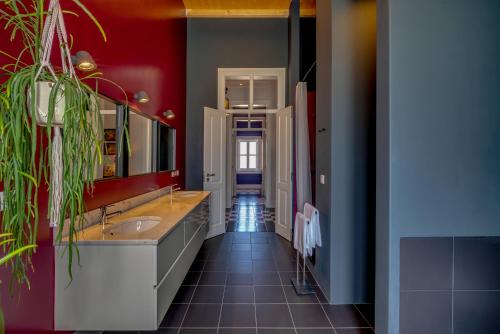 托马尔Best Luxury Boutique B&B Vista do Vale Tomar的浴室设有两个水槽和红色的墙壁