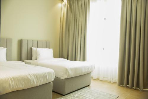 麦纳麦Super OYO Capital O 111 Infinity Suites的酒店客房设有两张床和窗户。