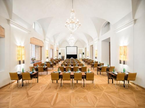 布拉格布拉格文华东方酒店的大房间设有桌椅和投影屏幕