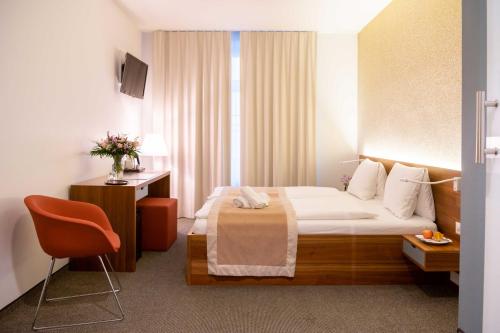 韦登斯维尔恩格尔班霍夫酒店的配有一张床和一把椅子的酒店客房