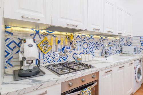 波西塔诺YourHome - Casa Moscatelli 150 steps的厨房配有白色橱柜和蓝色及白色瓷砖