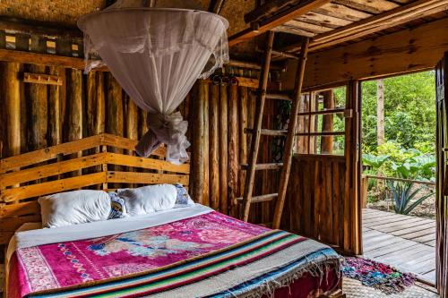 波特尔堡Kalitusi Nature Resort的小屋内的卧室配有一张床和梯子