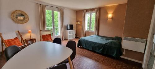 乌韦兹河畔莫朗Logis Hôtels Le Saint Marc的配有一张床和一张桌子及椅子的房间