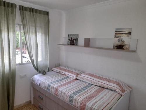 圣玛丽亚港Las Dunas的一间小卧室,配有一张带窗户的床