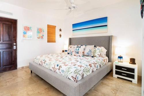 普罗维登西亚莱斯岛The Cottonwood House - Beach Villa的一间卧室配有一张床和一张桌子及床头柜
