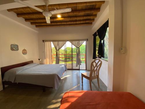 Las TunasHosteria Guachapeli的一间卧室设有两张床、一把椅子和一个窗户。