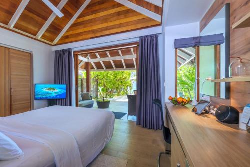希曼杜岛马尔代夫坎德鲁度假酒店的一间卧室配有一张床和一台电视。