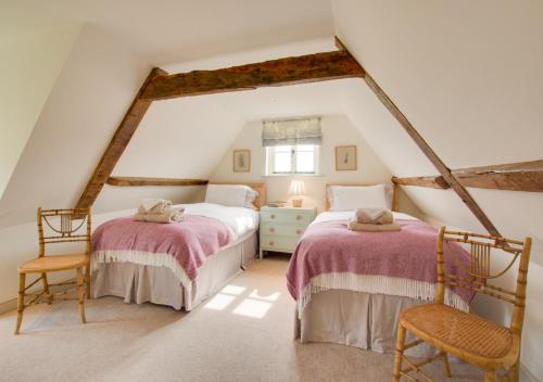BramptonManor Farm的阁楼卧室配有2张床和2把椅子