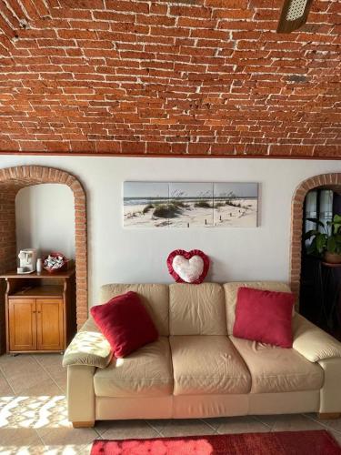 Fara NovareseCentenario affittacamere的带沙发和砖墙的客厅