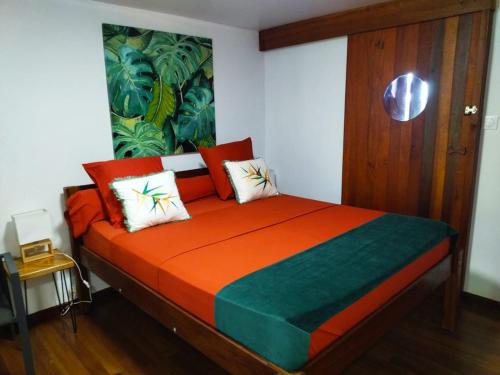 BourdaLE CHALET DOMAINE DU ROCHER的一间卧室配有一张带橙色和绿色棉被的床