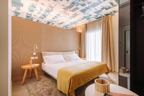 加利波利Biancodonda Lifestyle Hotel & SPA的酒店客房设有一张床和格子天花板