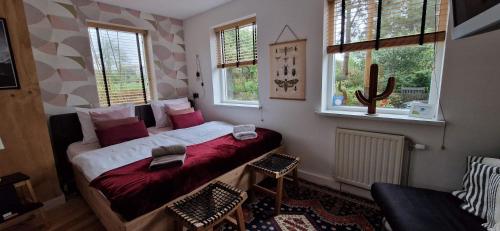 登海尔德B&B Duinbrink的一间卧室配有一张床、一把椅子和窗户。