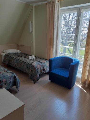 派尔努Inge Villa的一间卧室配有蓝色椅子、一张床和一个窗户